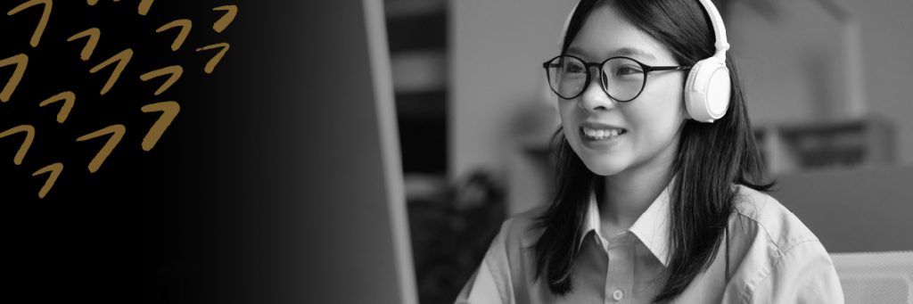 Woman wearing headphones looking at a computer screen