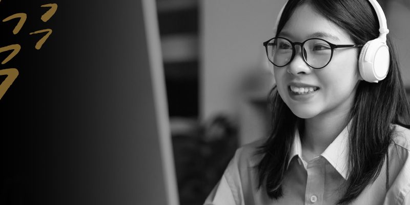 Woman wearing headphones looking at a computer screen