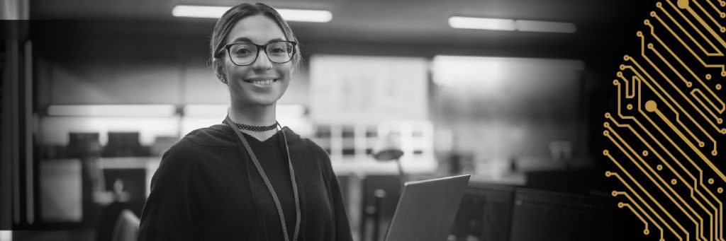 Front profile of a smiling woman wearing eye glasses and lanyard