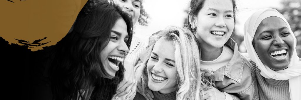 Group of woman of diverse ethnicities smiling and embracing one another