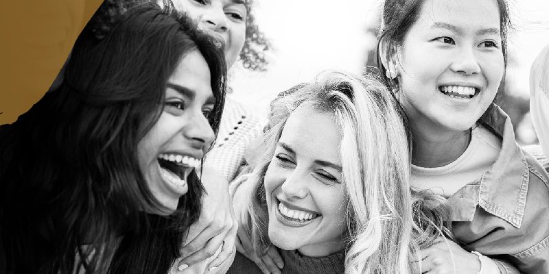 Group of woman of diverse ethnicities smiling and embracing one another