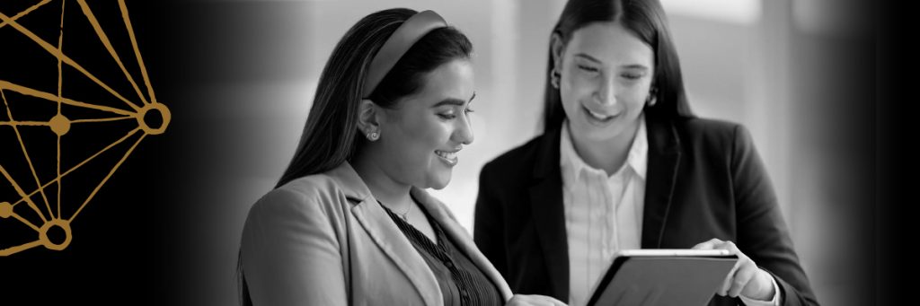 Two professional woman pointing at an ipad screen
