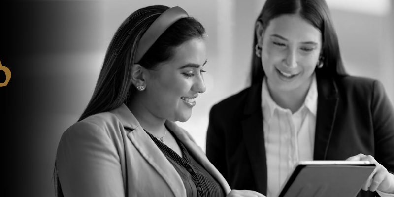 Two professional woman pointing at an ipad screen